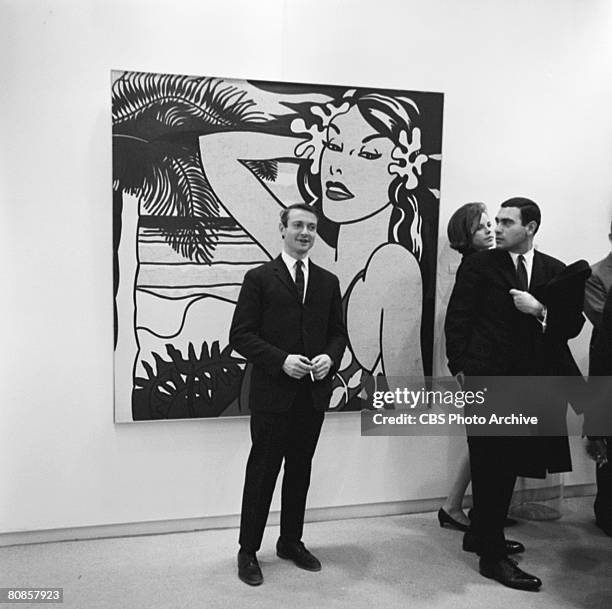 On an episode of the television documentary news program 'Eye on New York,' American artist Roy Lichtenstein poses in front of an unidentified...