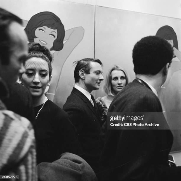 On an episode of the television documentary news program 'Eye on New York,' American artist Roy Lichtenstein attends the 'First International Girlie...