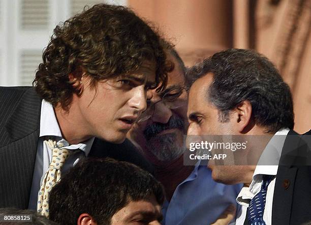 File photo of Argentine Economy Minister Martin Lousteau talking with Commerce Secretary Guillermo Moreno while Labor Minister Carlos Tomada looks on...