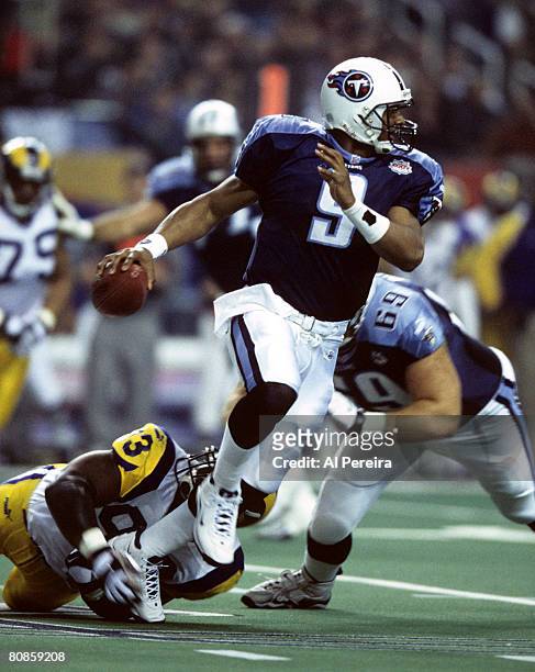 Tennessee Titans quarterback Steve McNair escapes the shoestring tackle of St. Louis Rams defensive end Kevin Carter during Super Bowl XXXIV, a 23-16...