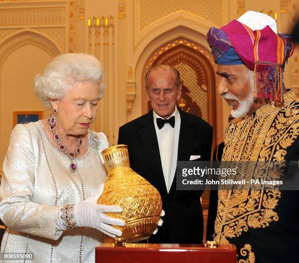 Queen Elizabeth II is delighted as the Sultan of Oman, His Majesty Sultan Qaboos bin Said presents her with a golden vase, before a State Banquet at...