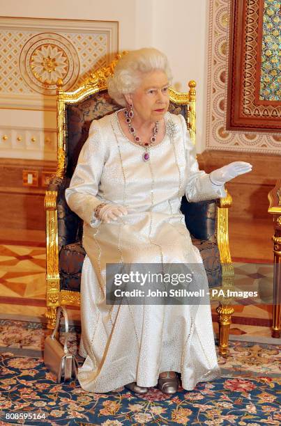 Queen Elizabeth II sits a talks to the Sultan of Oman, His Majesty Sultan Qaboos bin Said, before a State Banquet at his Palace in Muscat, Oman.