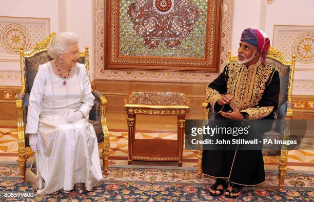 Queen Elizabeth II sits and talks with the Sultan of Oman, His Majesty Sultan Qaboos bin Said , before a State Banquet at his Palace in Muscat, Oman.