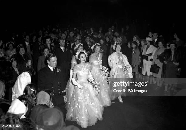 Bridesmaids and a cheering crowd watch as Princess Elizabeth and her husband, the newly created Duke of Edinburgh, leave in a carriage procession to...