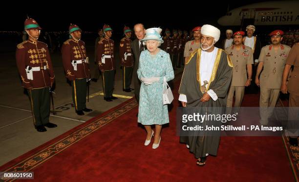 Queen Elizabeth II walks with the Sultan of Oman, His Majesty Sultan Qaboos bin Said, after arriving in Oman from the United Arab Emirates.