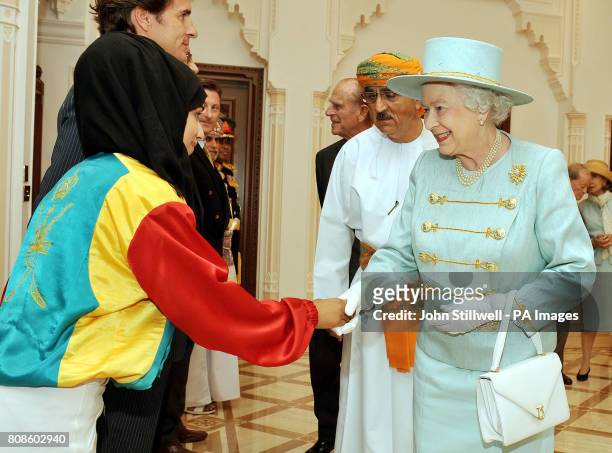 Queen Elizabeth II shakes hands with a female horse racing jockey, before she leaves with the Sultan of Oman His Majesty Sultan Qaboos bin Said and...
