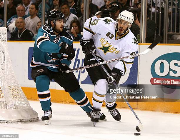 Mike Ribeiro of the Dallas Stars skates with the puck under pressure from Devin Setoguchi of the San Jose Sharks during game one of the Western...