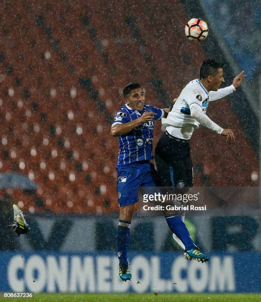 Facundo Cobos of Godoy Cruz fights for the ball with Lucas Barrios of Gremio during a first leg match between Godoy Cruz and Gremio as part of round...