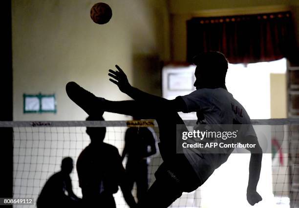 This photo taken on May 22, 2017 shows a member of Indonesia's national sepak takraw team performing a kick to fire a ball over the net during a...