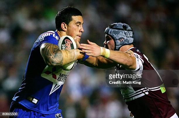 Sonny Bill Williams of the Bulldogs puts a fend on Adam Cuthbertson of the Sea Eagles during the round seven NRL match between the Manly Warringah...