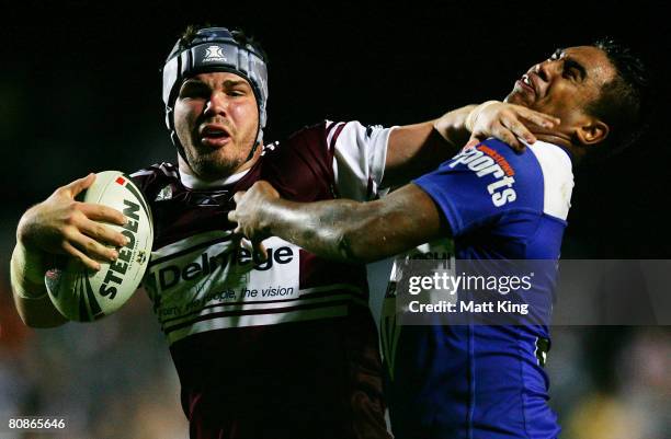 Adam Cuthbertson of the Sea Eagles tries to fend off Keka Nanai of the Bulldogs during the round seven NRL match between the Manly Warringah Sea...