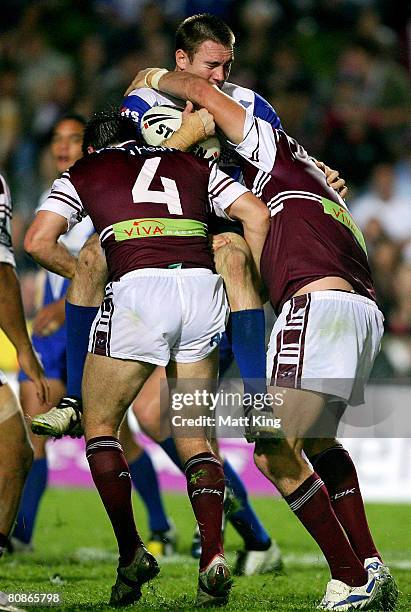 Brent Crisp of the Bulldogs is tackled heavily by the Sea Eagles defence during the round seven NRL match between the Manly Warringah Sea Eagles and...