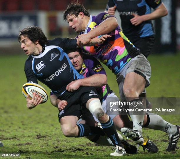 Glasgow's Colin Gregor is tackled by Edinburgh's Ross Ford and Allan Jacobsen during the 1872 Cup match at Firhill Stadium, Glasgow.