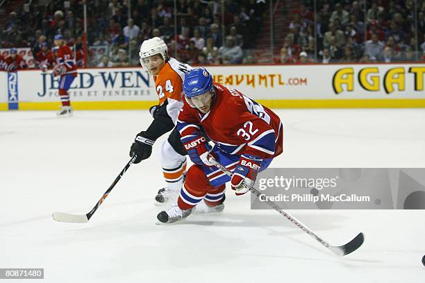 Mark Streit of the Montreal Canadiens passes the puck against Sami Kapanen of the Philadelphia Flyers during Game One of the Eastern Conference...