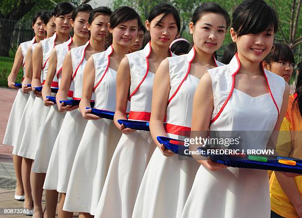 To go with OLY-2008-CHN-100DAYS by Charles Whelan Hostesses carry trays of wrist bands for a presentation ceremony ahead of a walkathon on April 26,...