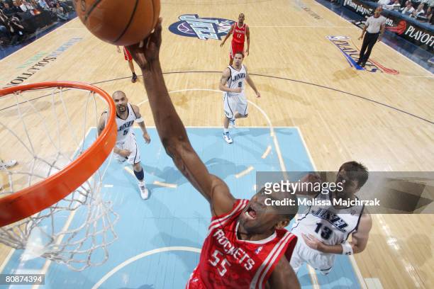 Dikembe Mutombo of the Houston Rockets scores a layup on Mehmet Okur of the Utah Jazz in Game Four of the Western Conference Quarterfinals during the...