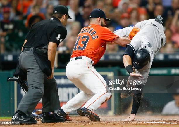 Austin Romine of the New York Yankees is tagged out by Lance McCullers Jr. #43 of the Houston Astros as he attempts to score at Minute Maid Park on...