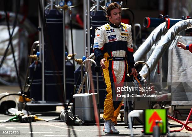 Fernando Alonso of Spain and Renault walks down the pitlane after retiring from the Spanish Formula One Grand Prix at the Circuit de Catalunya on...