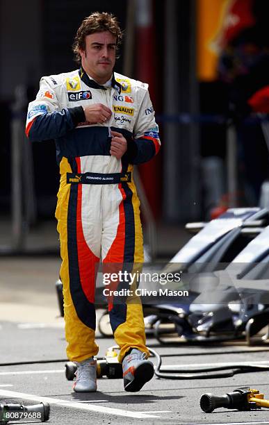 Fernando Alonso of Spain and Renault walks down the pitlane after retiring from the Spanish Formula One Grand Prix at the Circuit de Catalunya on...