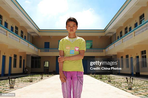 Fourteen-year-old Cai Fengjiao, an orphan from the Chelutang Village, poses for pictures in a school at the Kelu Township on April 19, 2008 in...