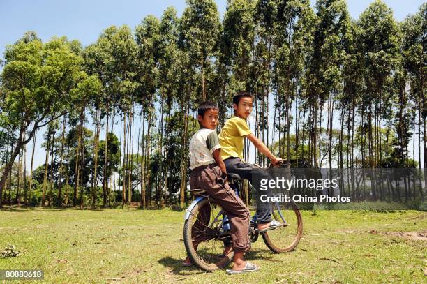 Fifteen-year-old Cai Pingyang and his brother Fourteen-year-old Cai Pinglong, orphans from the Maizai Village of Kelu Township, pose for pictures on...