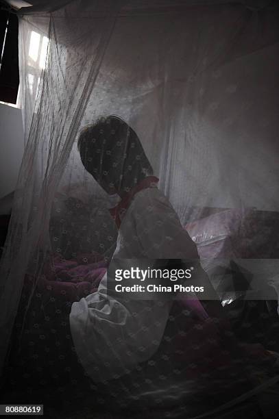 Fifteen-year-old He Tao, an orphan from the Leicheng Street lies in a bed on April 19, 2008 in Zhanjiang of Guangdong Province, China. According to...