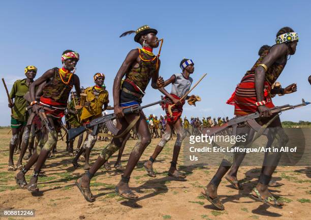 Men running in line with weapons during the proud ox ceremony in the Dassanech tribe, Turkana County, Omorate, Ethiopia on June 6, 2017 in Omorate,...