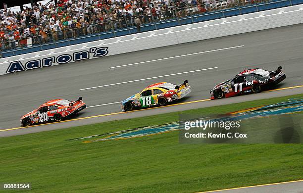 Tony Stewart, driver of the Home Depot Toyota, leads Kyle Busch, driver of the M&M's Toyota, and Denny Hamlin, driver of the FedEx Toyota, during the...