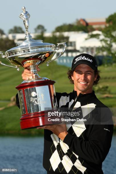 Adam Scott of Australia holds the trophy after his victory over Ryan Moore on the third playoff hole during the final round of the EDS Byron Nelson...