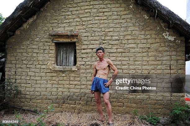 Zhang Qianyou, a 53-year-old farmer stands in front of his house at the Yanlou Village April 21, 2008 in Zhanjiang of Guangdong Province, China....