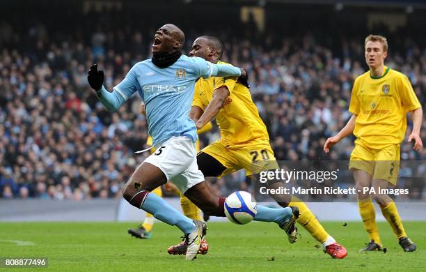 Manchester City's Mario Balotelli goes to ground after a challenge by Notts County's Craig Westcarr