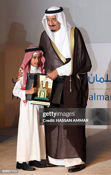 Prince Faisal bin Ahmad bin Salman presents a commemorative plaque to his grandfather Riyadh Governor Prince Salman bin Abdul Aziz al-Saud during the...