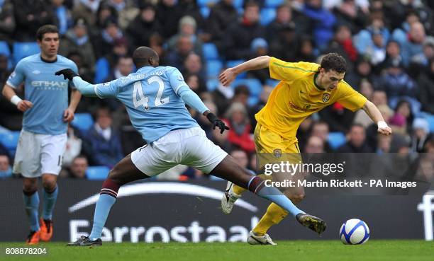 Notts County's Alan Gow skips past the challenge from Manchester City's Gnegneri Toure Yaya