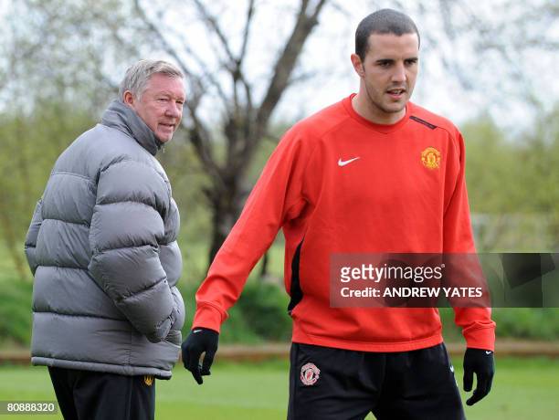Manchester United manager Sir Alex Ferguson walks past Manchester United's Irish defender John O'Shea during a team training session at the...