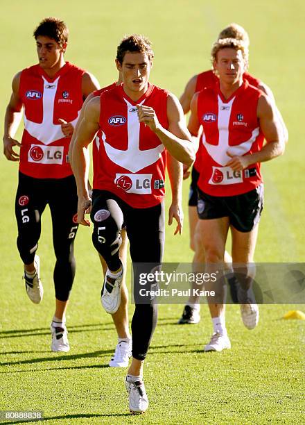 Daniel Gilmore of the Dockers leads Garrick Ibbotson and Shaun McManus in a warm up drill during an AFL Fremantle Dockers training session at...