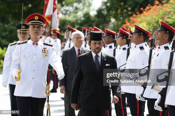 Sultan of Brunei Hassanal Bolkiah inspects the guard of honour, accompanied by Singapore President, Tony Tan Keng Yam during the welcome ceremony at...