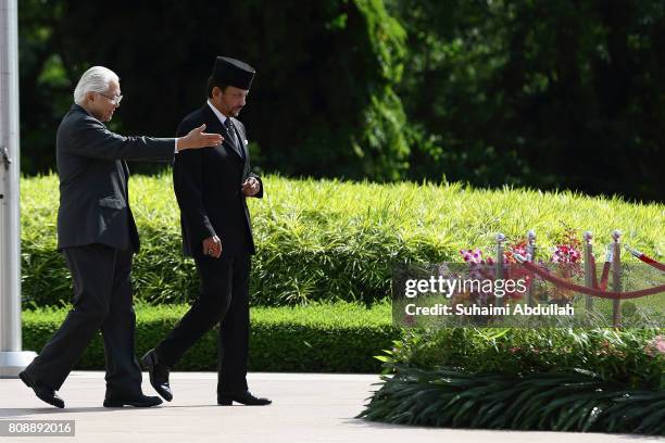 Sultan of Brunei Hassanal Bolkiah arrives at the official welcome ceremony, accompanied by Singapore President, Tony Tan Keng Yam at the Istana on...