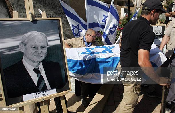 Israelis walk past a portrait of Yossi Harel as they carry his coffin during a memorial ceremony in Tel Aviv on April 28, 2008. Harel, the captain of...