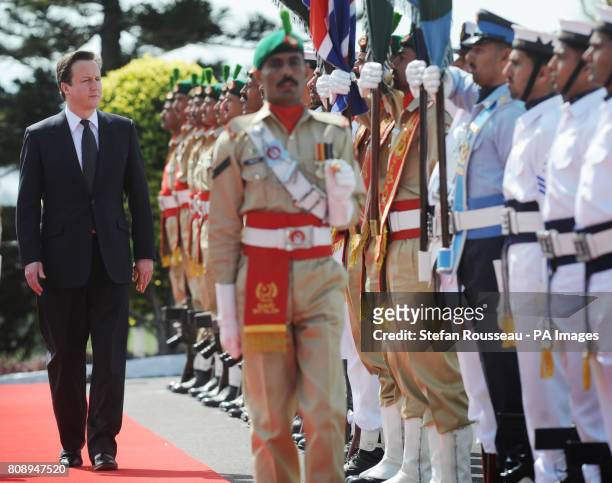 Prime Minister David Cameron inspects a guard of honour at the Pakistan Prime Minister Yousuf Raza Gilani's residence in Islamabad where the two held...