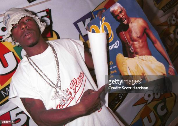 Sisqo holds up a poster of himself backstage at a concert June 10, 2000 in Las Vegas, Nevada.
