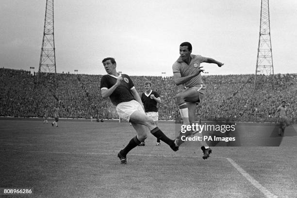 Servilho shoots the equalising goal for Brazil, depsite the attentions of Scotland's John Greig and Billy Bremner .