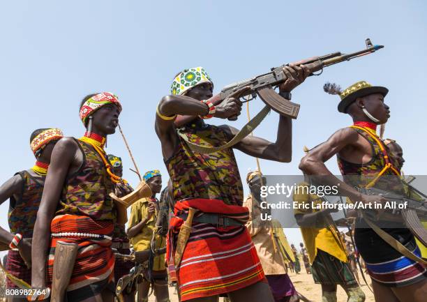 Man shooting with a kalashnikov during the proud ox ceremony in the Dassanech tribe, Turkana County, Omorate, Ethiopia on June 6, 2017 in Omorate,...