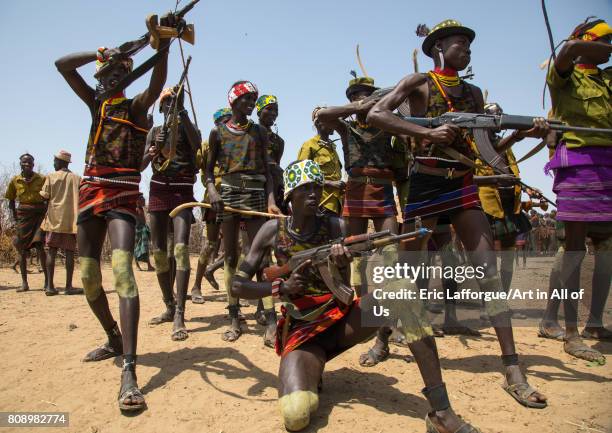 Men shooting with kalashnikovs during the proud ox ceremony in the Dassanech tribe, Turkana County, Omorate, Ethiopia on June 6, 2017 in Omorate,...