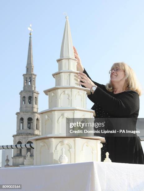 Cake maker Dawn Blunden, from Sophisticake, places the top on a four foot high medieval wedding cake, which replicates the steeple and spire of St...