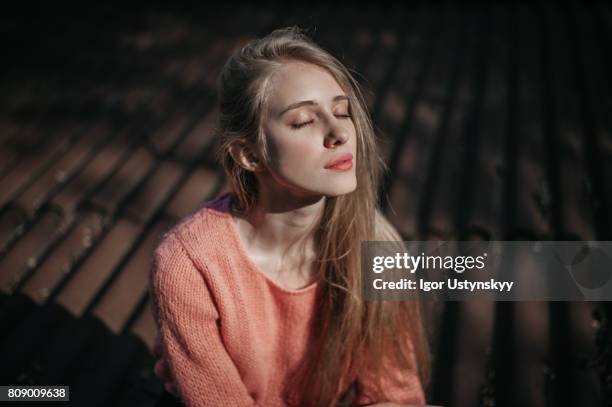 woman sitting on the roof at sunrise - woman on walking in countryside stock-fotos und bilder