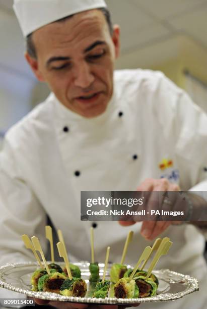 Royal Chef, Mark Flanagan, Head of Kitchens at Buckingham Palace, arranges a tray of Bubble and Squeak Confit with Shoulder of Lamb canapes, food...