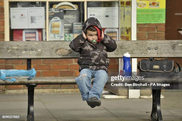 Young boy puts his hands over his ears as motorbike riders for the Ride of Respect charity pass through the Wiltshire town of Wootton Bassett, in aid...