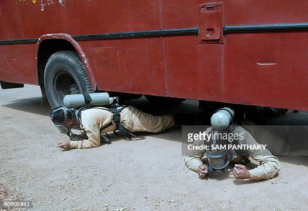 Indian officer from the National Fire Service College wear breathing apparatus as they perform a crawling drill during a training session on the...