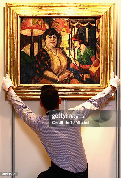 Technician from Sotheby's auctioneers holds Anita and Myself, a painting by Margret Morris, at a showcase of 20th century Scottish art in the...