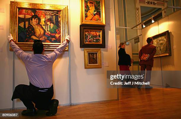 Technician from Sotheby's auctioneers holds Anita and Myself, a painting by Margret Morris, at a showcase of 20th century Scottish art in the...